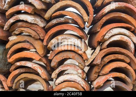 Red tiles for the roof of the building, close-up. The concept of building construction and roofs. Stock Photo
