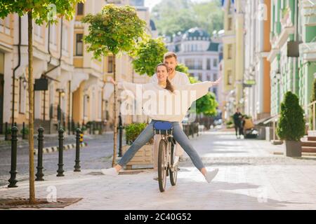 Man on bicycle carrying woman sitting in front Stock Photo