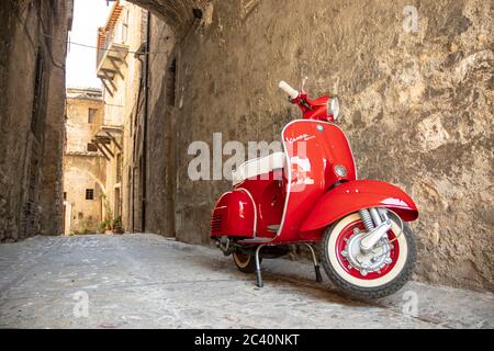 June 30, 2019 - Rome, Lazio, Italy - A red Piaggio Vespa Sprint, parked in an alleyway of an ancient village, in Italy. The scooter symbol of Italian Stock Photo