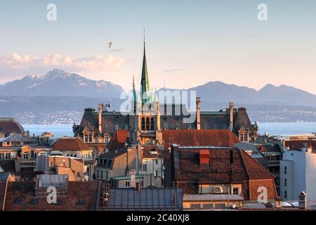 Skyline of Lausanne, Switzerland as seen from the Cathedral hill at sunset zoomed-in on the tower of St-Francois Church. Lake Leman (Lake Geneva) and Stock Photo