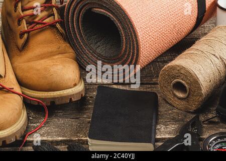 Hiking boots and rope hank on wooden board Stock Photo