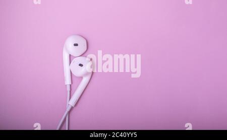 Lovely earphones. White earphones on pastel pink background. Music is my life concept. Valentine concept. World music day. Stock Photo