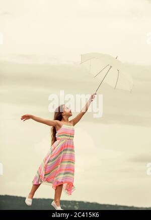Girl with light umbrella. Fairy tale character. Happy childhood. Feeling light. Anti gravitation. Fly drop parachute. Dreaming about first flight. Kid Stock Photo
