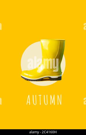 Bright yellow rubber boot against the same color. A minimalist concept on the theme of autumn. Stock Photo