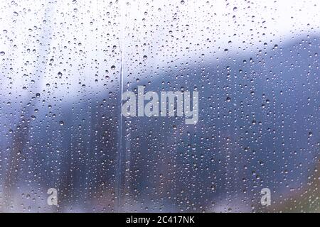 Raindrops on window glass with blur background Stock Photo