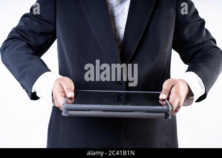 Closed up shot of a man in suit holding a tablet on a hite background Stock Photo