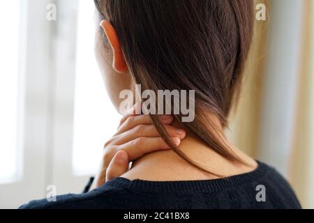 Woman with neck pain touching her neck. Neck pain concept. Stock Photo