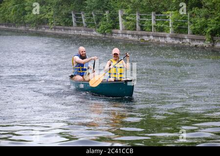 Young couple rowing fast for shelter as they were caught in canoe in Canal in Ottawa when heavy storm rolled in Stock Photo