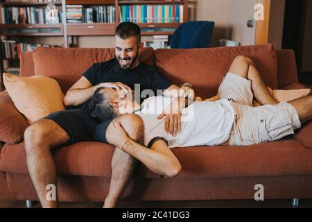 gay couple having fun and laughing on the couch Stock Photo