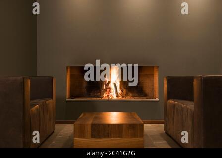 Armchairs in front of a log fire - luxury lounge Stock Photo