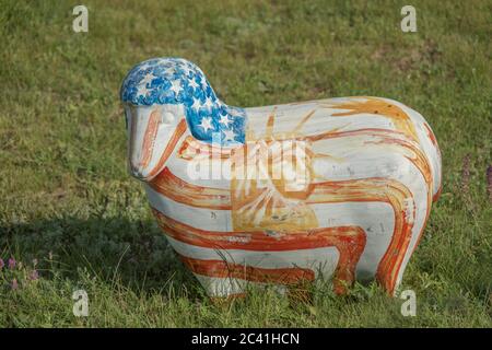 Sculpture of colored Lambs in colors american flag on Green Grass in the village. Frumushika Nova, Odessa region, Ukraine, Eastern Europe Stock Photo