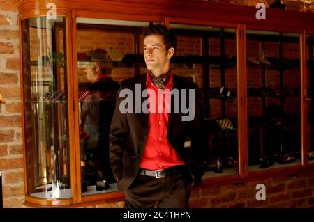 Well-dressed young man stands in front of a showcase with ties - men's boutique Stock Photo