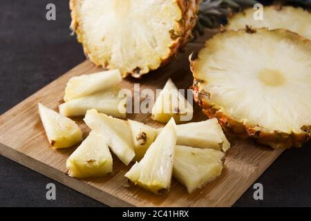 Fresh pineapple slices on black slate background Stock Photo