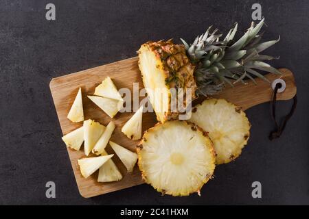 Fresh pineapple slices on black slate background Stock Photo