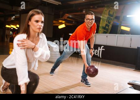 A beautiful loving caucasian couple throwing balls on the bowling alley. Boyfriend and girlfriend at the bowling club Stock Photo