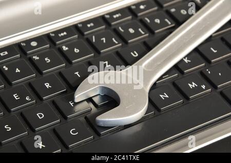 Wrench lying on computer keyboard symbolizing IT maintenance Stock Photo
