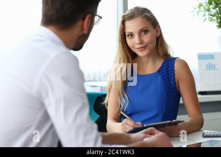 Charming young woman working with colleague in office Stock Photo