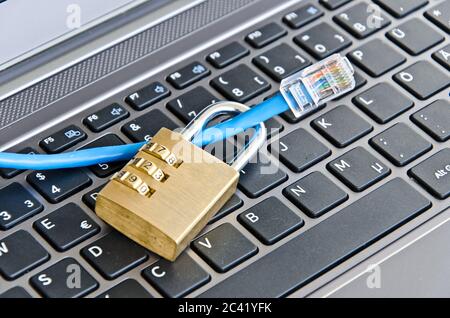 Internet cable and padlock on computer keyboard symbolizing data security Stock Photo