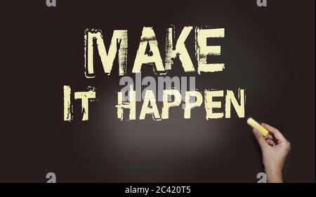 Make It Happen written in chalk on a used blackboard. Used in business, life and sports coaching this well known phrase or saying has become a Stock Photo