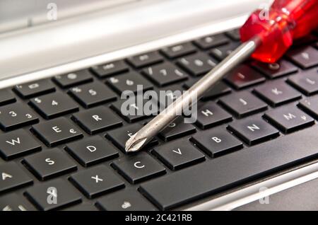 Screwdriver on computer keyboard symbolizing IT maintenance Stock Photo