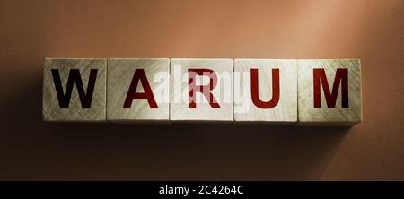 Wooden cubes showing the German word for Why, German: Warum . Cause concept Stock Photo