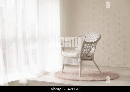 White wicker armchair standing in empty modern room with carpet Stock Photo