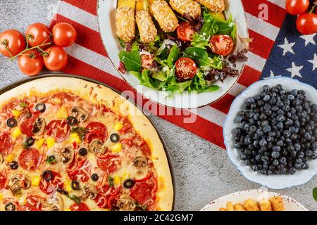 Independence Day party table with delicious food and flag for american holiday. Stock Photo