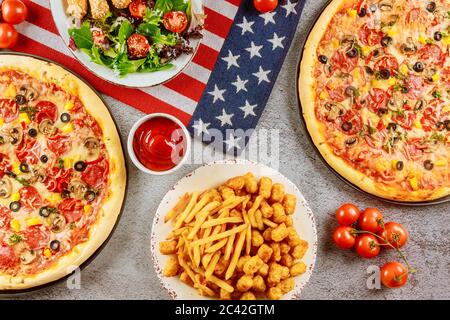 Party for american holiday with supreme pizza on rustic wooden table. Stock Photo