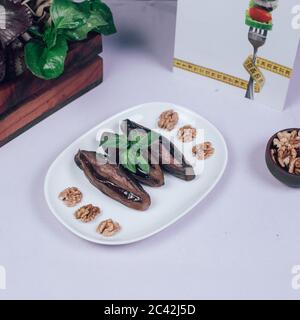 Fried whole eggplants served with walnuts Stock Photo