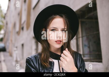 portrait of young woman wearing black hat Stock Photo