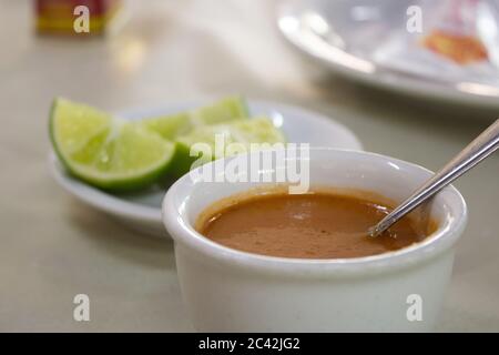 Pepper sauce and lemons, served to go with fish on a restaurant Stock Photo