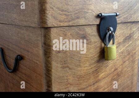 Old wooden locking box with a padlock on the spot Stock Photo