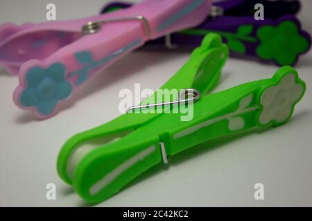 Closeup on a green plastic clothespin with others on the background Stock Photo