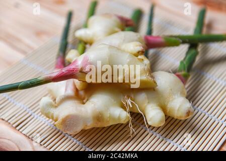 Young ginger slice for herb medicinal natural and food / Fresh ginger root harvest on wood Stock Photo