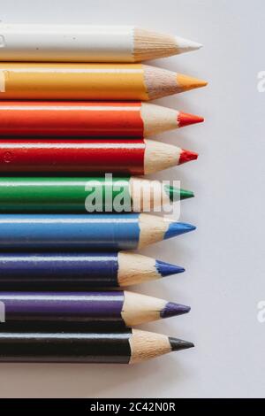 Rainbow of coloring pencils on plain white background Stock Photo