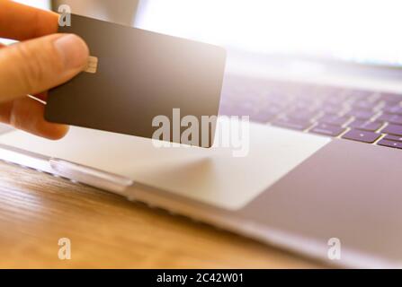 Hand Holding Credit Card With Laptop To Make E Commerce Purchase Stock Photo