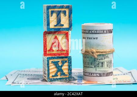 TAX wordings on woodens blocks with US Dollar bills Stock Photo