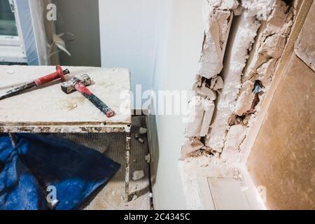 Workmen's tools that soundproof the walls of a room with white polystyrene. Stock Photo