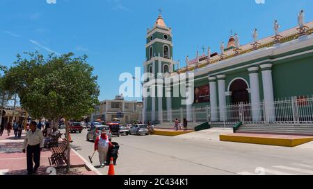 Catacaos, Piura / Peru - April 6 2019: Cars circulating in front of the church San Juan Bautista next to the main square in the center of town of Cata Stock Photo
