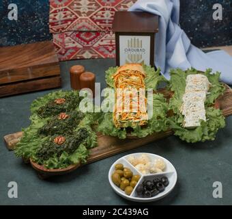 Green herbal omlette on a lettuce leaf on a wooden board served with cheese and olives Stock Photo