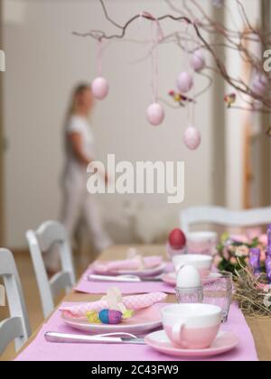Laid Easter table with woman in background, Munich, Bavaria, Germany Stock Photo