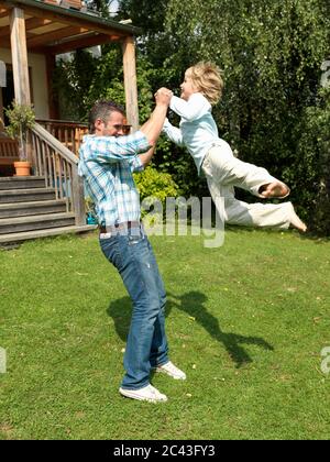 Father plays with son in the garden, Munich, Bavaria, Germany Stock Photo