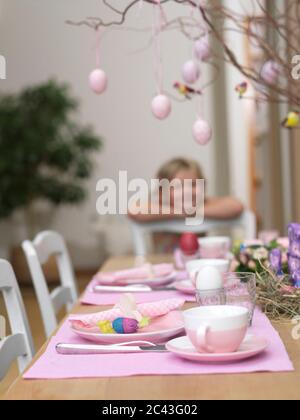 Laid Easter table with girl in the background, Munich, Bavaria, Germany Stock Photo