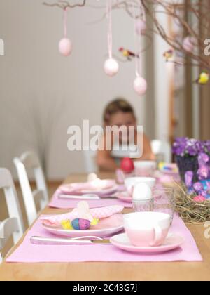 Laid Easter table with girl in the background, Munich, Bavaria, Germany Stock Photo