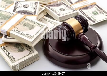 Money influence in the legal court system, corruption, auction bidding and bankruptcy conceptual idea with wood judge gavel and wad or bundle of cash