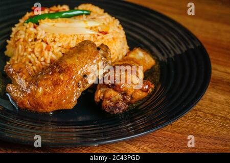 Spicy fried rice with grilled black pepper chicken wings. Stock Photo
