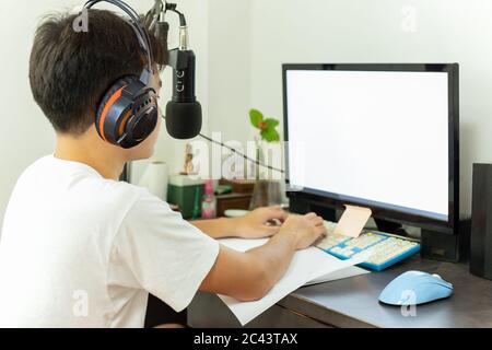 Asian teenage boy study at home uses pc online class during Quarantine covid-19. Stock Photo