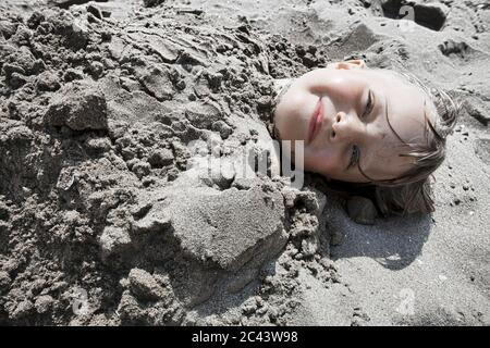 Girl buried in sand Stock Photo