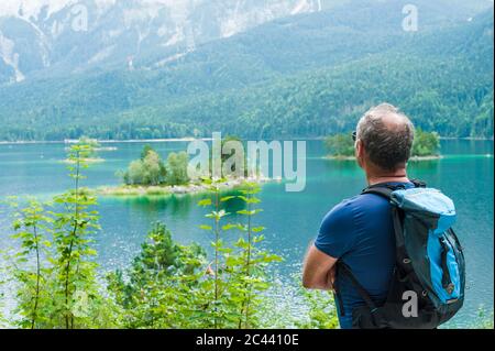 Senior man enjoying view over Eibsee Stock Photo