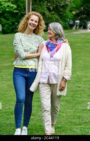 Happy senior woman walking with daughter in park Stock Photo